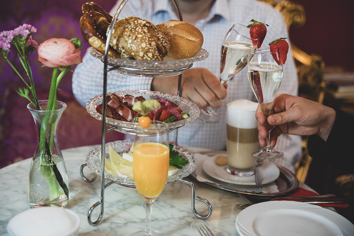 2 Personen stoßen beim Brunch mit Sekt an