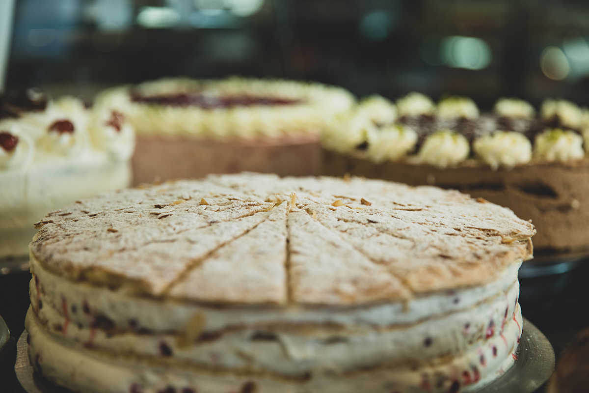 Das Bild zeigt eine Torte mit mehreren Torten im Hintergrund